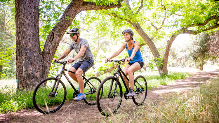 Couple riding bikes on a dirt path