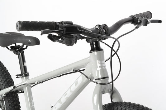 Close-up of the Flightline 20 Plus Disc’s gray handlebars, brake levers, cables, and saddle against a white background.