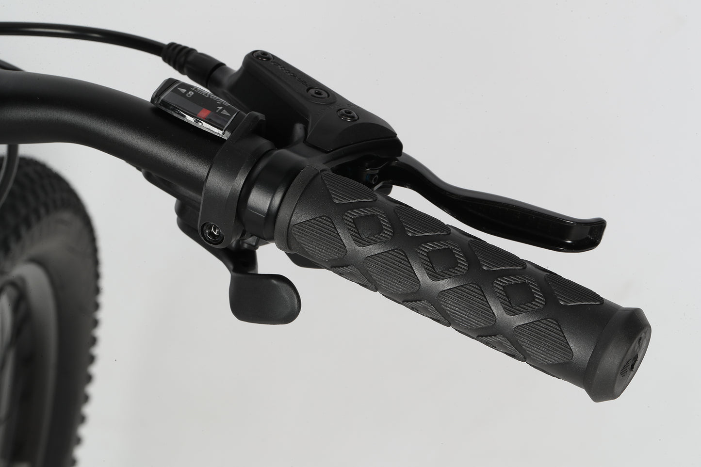 Close-up of the Flightline 20 Plus Discs black handlebar with textured grip, brake lever, and gear shifter against a light background.