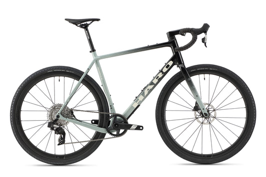The Buzzard Carbon 2 is a sleek, light gray road bike with SRAM Apex electronic groupset, disc brakes, and drop handlebars on a white background.