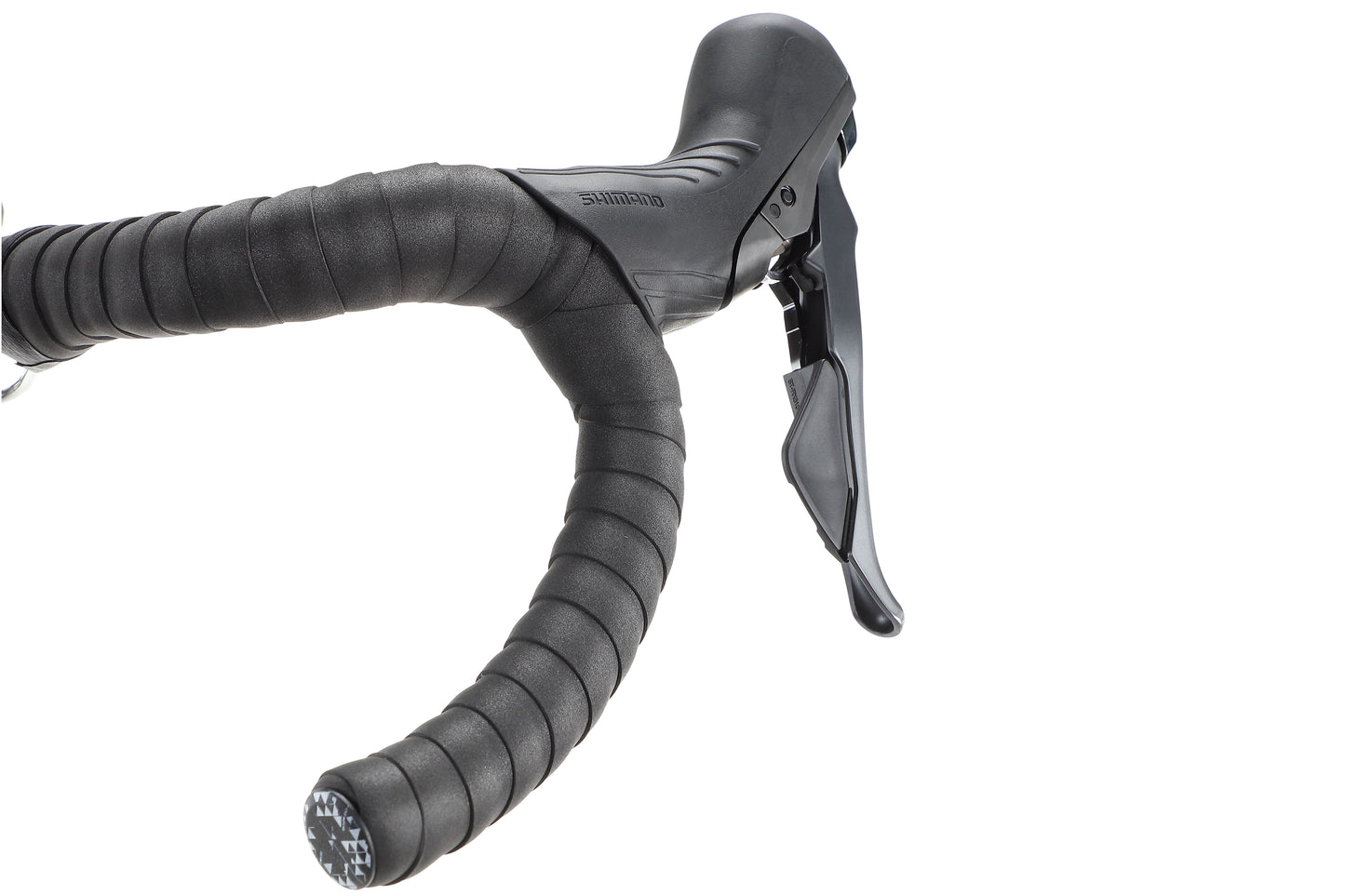 Close-up of Buzzard Carbon 3s handlebar, wrapped in black grip tape with gear shifter and brake lever, set against a white background by Haro Bikes. Perfect for bikepacking adventures where comfort and control are key over long distances.
