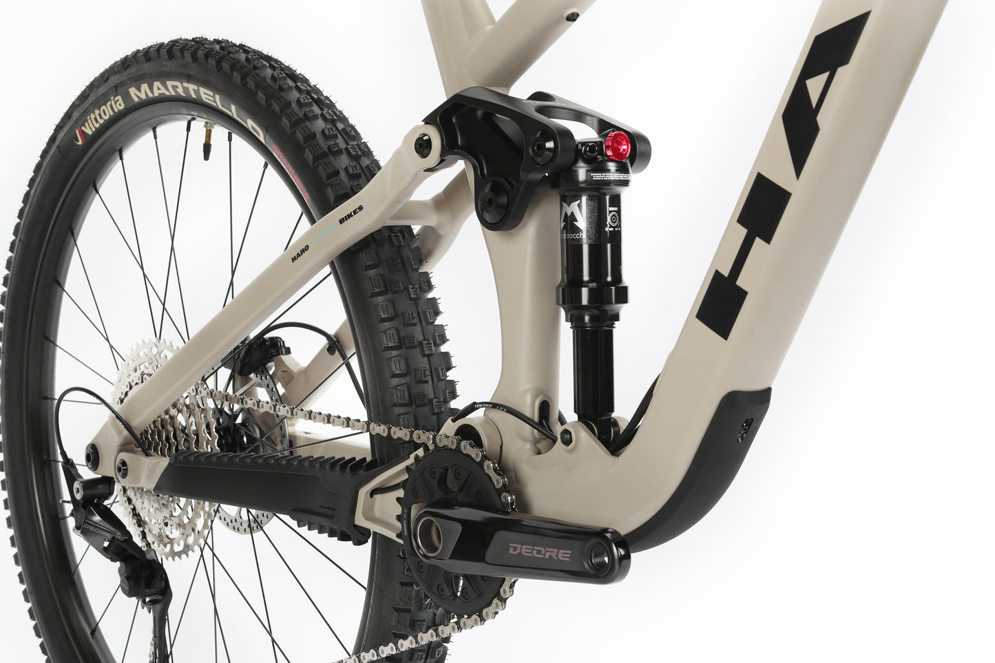 Close-up of Daley Alloy 2’s rear suspension, DEORE crank, drivetrain, and tire on an all-mountain 29er aluminum frame.
