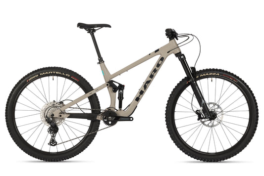 A tan Daley Alloy 2 all-mountain 29er with suspension, black wheels, disc brakes, and a slanted top tube in side profile.