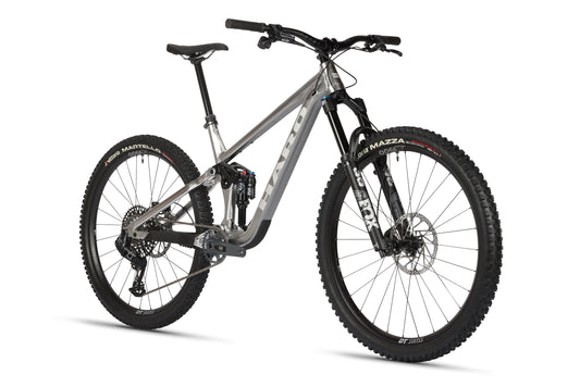 The Daley Alloy LTD 1 is a modern silver MTB with black handlebars, thick tires, and full suspension, seen from a front-side view.
