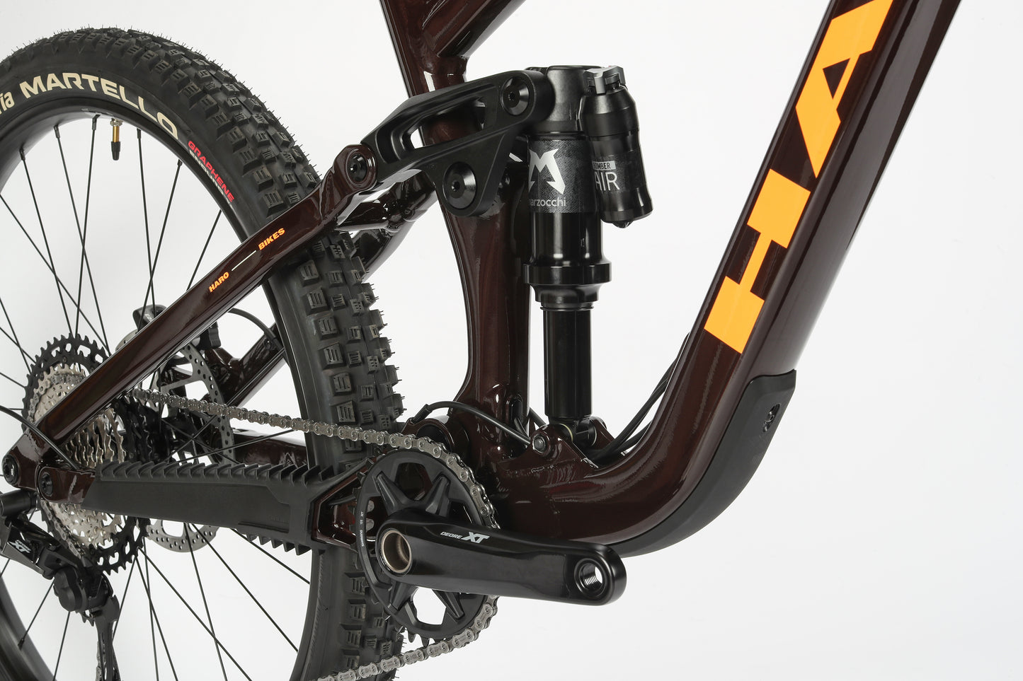 Close-up of Greer Alloy 1’s progressive suspension, crankset, and tire, highlighting detailed components and alloy frame.