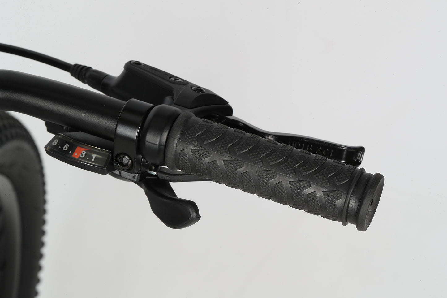 Close-up of the Flightline 24 Plus Discs handlebar with textured rubber grip, gear shifter, and brake lever against a plain background.