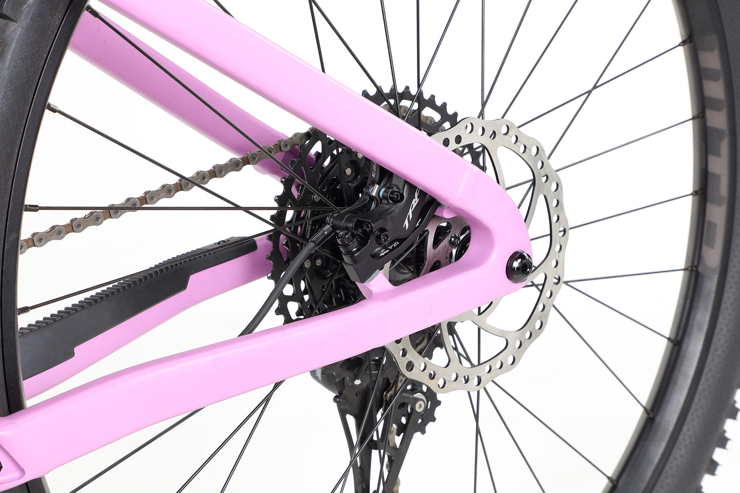Close-up of a Haro MTB Saguaro 2 bikes rear wheel featuring a pink frame, disc brake rotor, chain, and gear cassette. The hardtails aggressive geometry stands out against a plain white background.