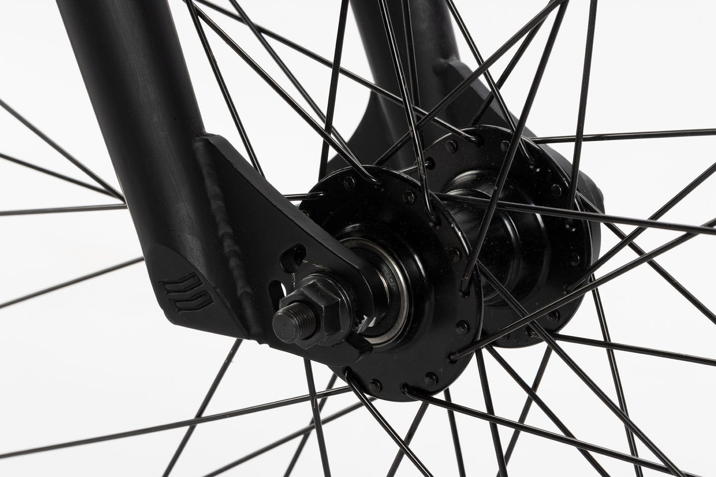 Close-up of Steel Reserve 1 front wheel hub with metal spokes, axle, and black fork against a white background.