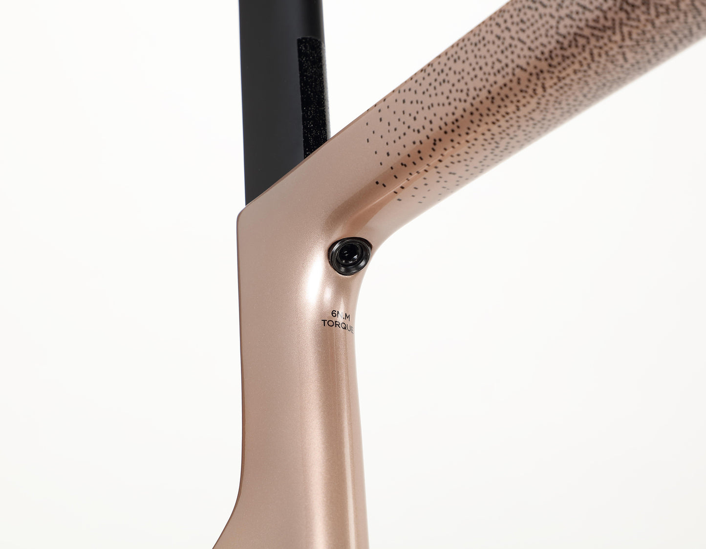 Close-up of the Haro Bikes Rivette Carbon 2 chairs backrest and frame connection. The champagne-finished metallic frame has a sleek, dotted carbon fiber-style pattern. A black screw is visible at the joint against a plain white background.