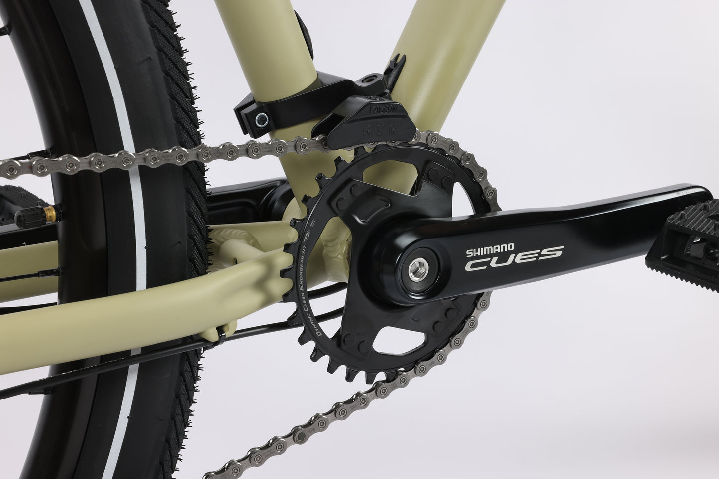 Close-up of a Shimano Cues drive-train with a black pedal on the beige 29 Beasley One frame in the background.