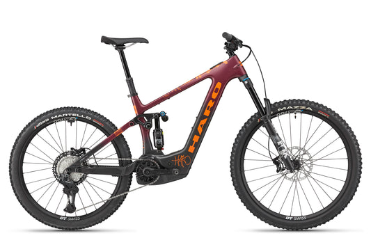 The eGreer Carbon 1 is a maroon and orange full-suspension mountain bike with FOX Factory suspension, thick tires, and disc brakes.