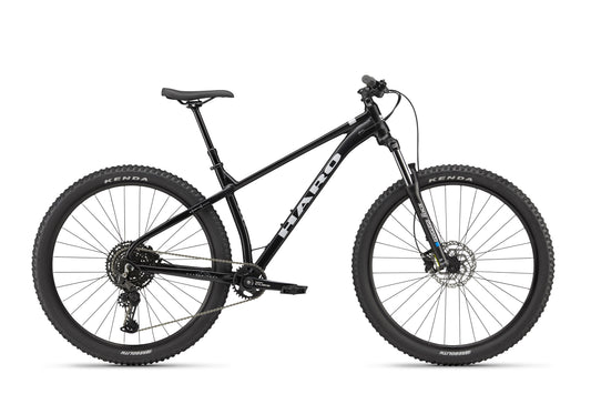 Double Peak black mountain bike with front suspension, hydraulic disc brakes, knobby tires; side view on white background.