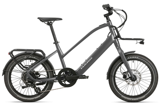Skwad LT matte grey city e-bike with pedal assist, black saddle, disc brakes, racks; side view on white background.