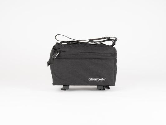 The Atran Velo ZAP EASY Top Bag in black features a top zipper and logo on the front. It uses the AVS system with two loops for easy bike mounting. Its compact, water-resistant design makes it ideal for carrying small items, all set against a plain white background.
