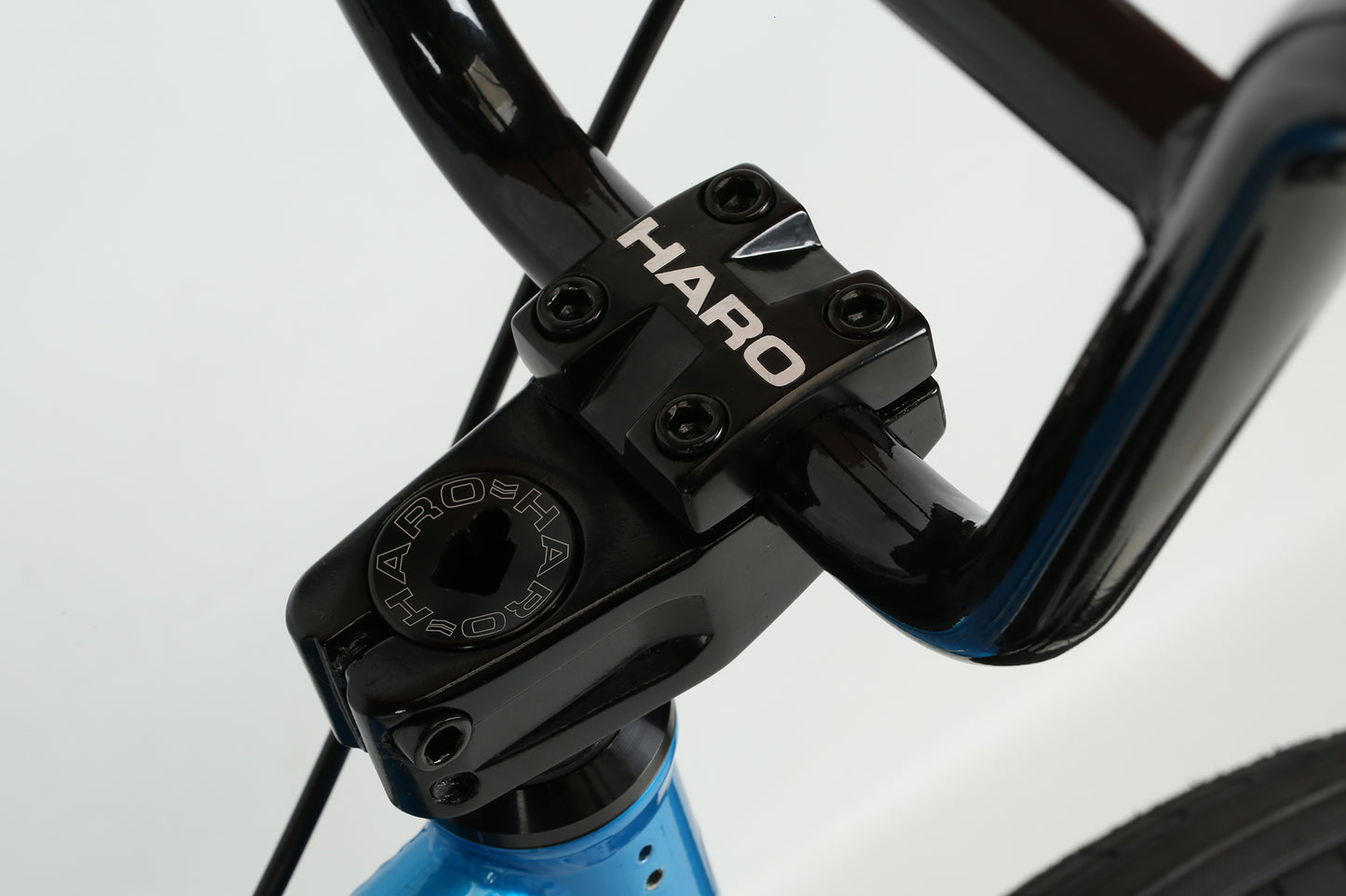 Close-up of a black bicycle stem with Haro Bikes in white letters. The black handlebars match the blue chromoly frame, featuring a Midway Freecoaster hub for smooth riding.