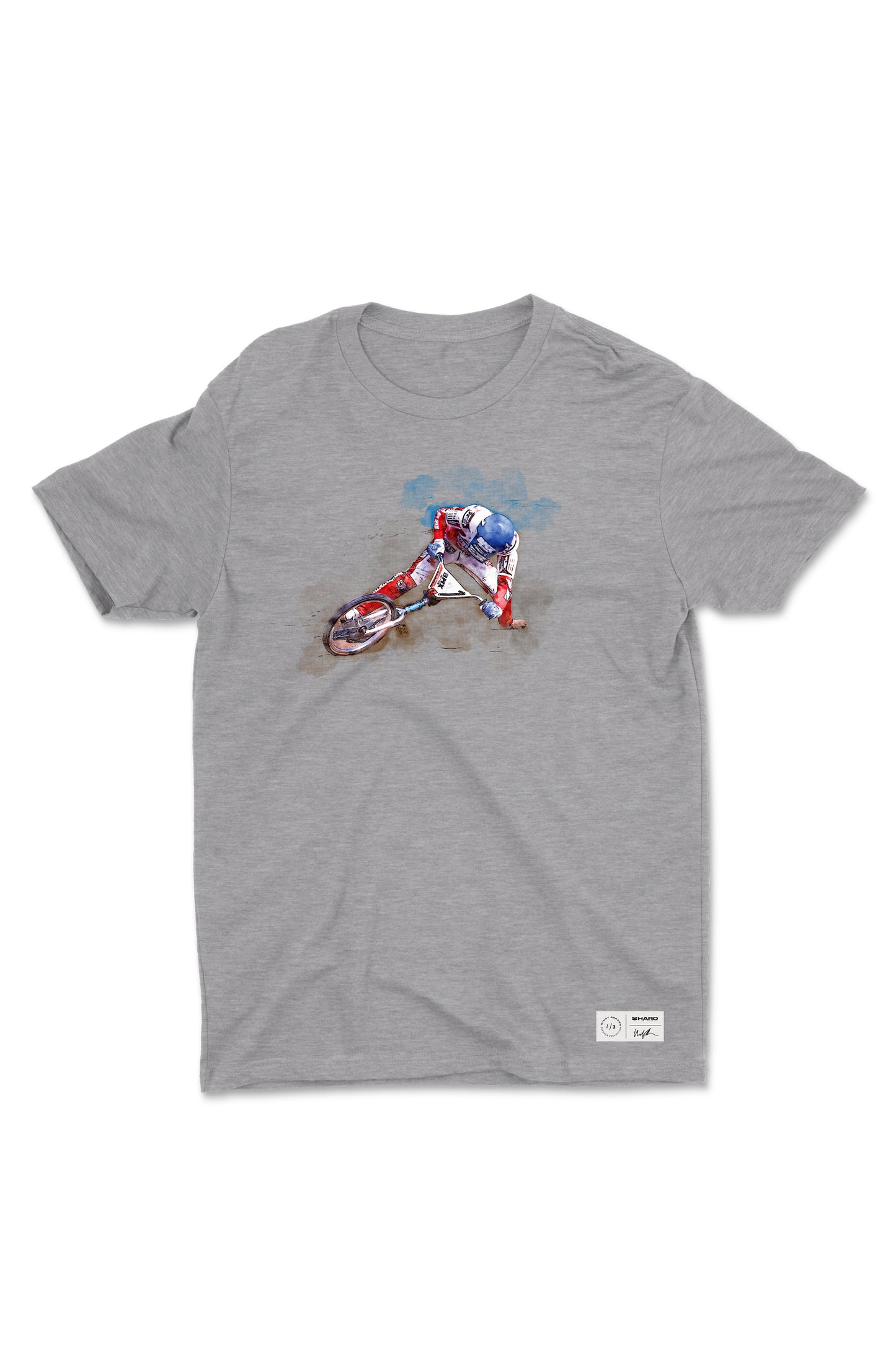 The Windy Osborn Mens Slide Shirt from Haro Bikes is a gray crew neck tee featuring a cyclist in a colorful outfit leaning into a turn. Made from fine jersey combed ring-spun cotton, it showcases a dynamic, artistic style with vibrant colors around the cyclist.