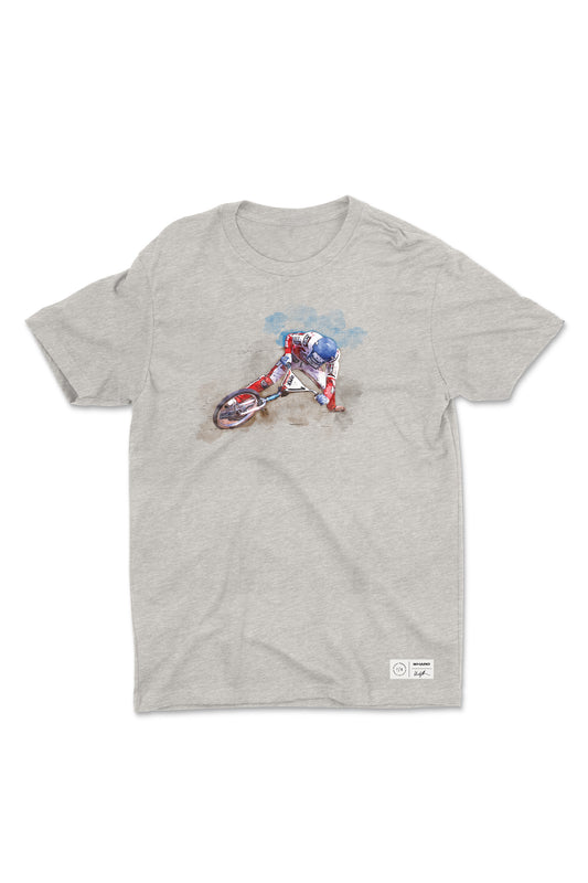 The Windy Osborn Mens Slide Shirt by Haro Bikes is a gray crew neck tee made from combed ring-spun cotton. It features a watercolor-style illustration of a cyclist in motion with earthy tones and a subtle blue background on fine jersey fabric.