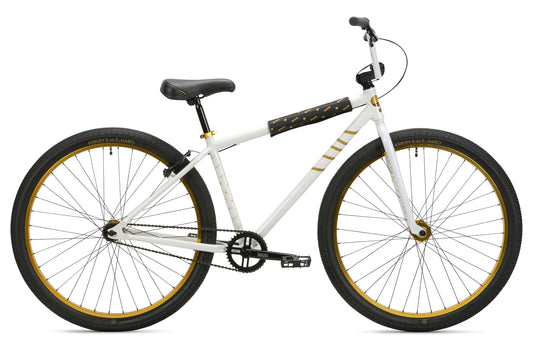 The Haro Bikes B.M.F 29 is a white BMX bicycle featuring black and gold accents, large wheels, a black seat and handlebars, a single-speed chain, and a sleek frame design. Perfect for the Bike Life vibe on a white background.