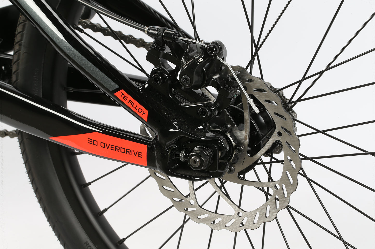 Close-up of Blackout bicycles rear disc brake and spokes, featuring a race-ready black and orange design with TB ALLOY and 3D OVERDRIVE.