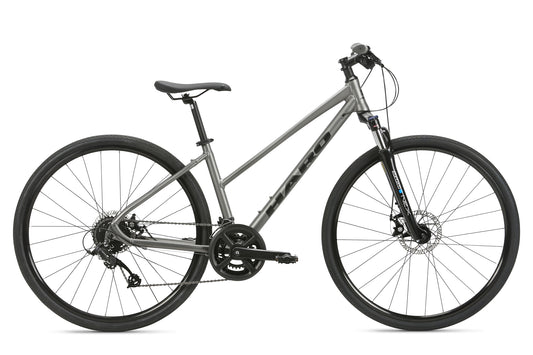 The Haro MTB Bridgeport ST MicroShift hybrid bike boasts a sleek gray step-through frame, suspension fork, disc brakes, and narrow tires for versatile urban commuting and light off-road trails. The brand name is prominently displayed on the frame.
