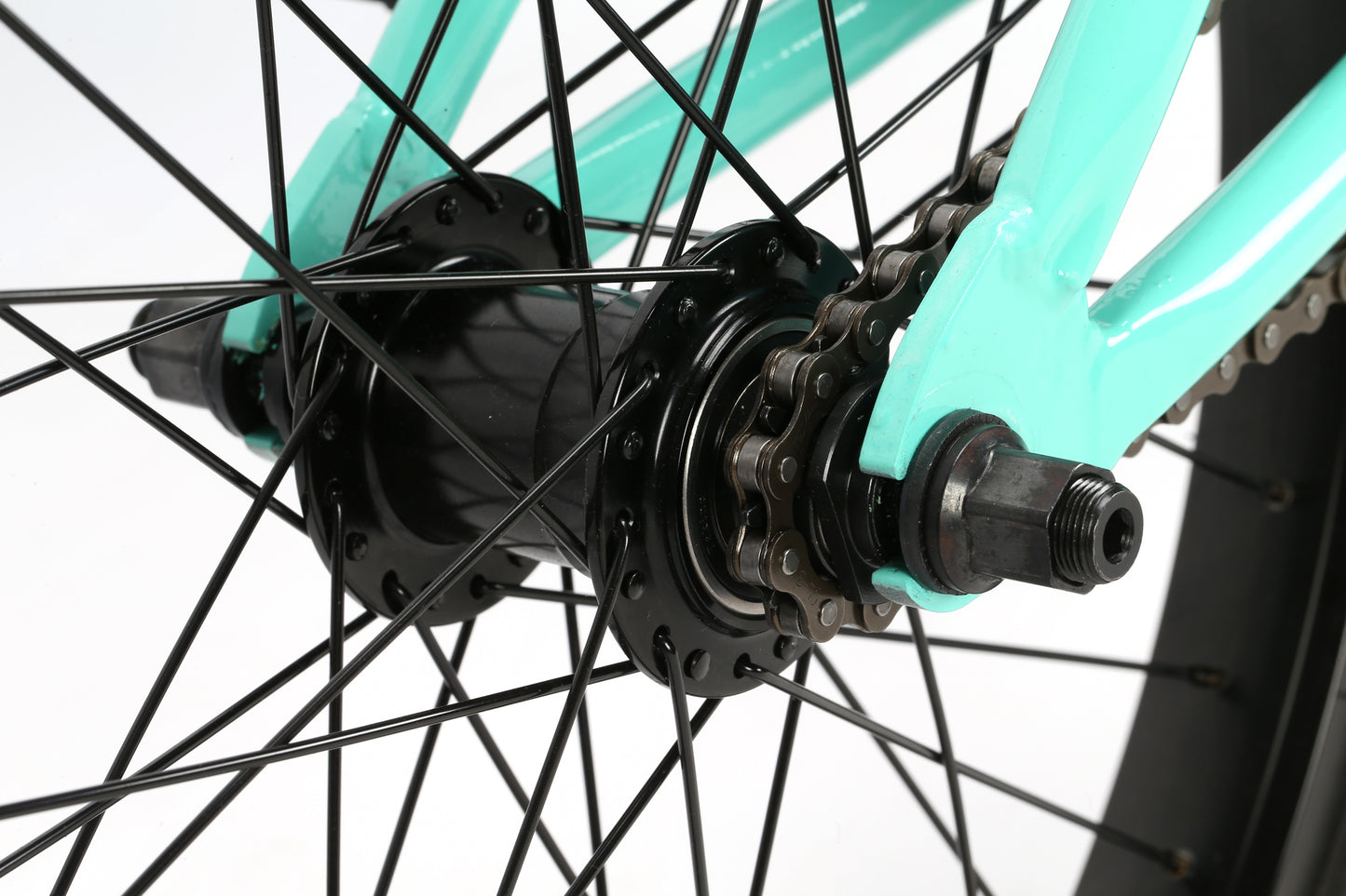 Close-up of La Bastille Freecoaster rear wheel with black spokes, hub, gears, and turquoise frame—perfect for flatland and freestyle.