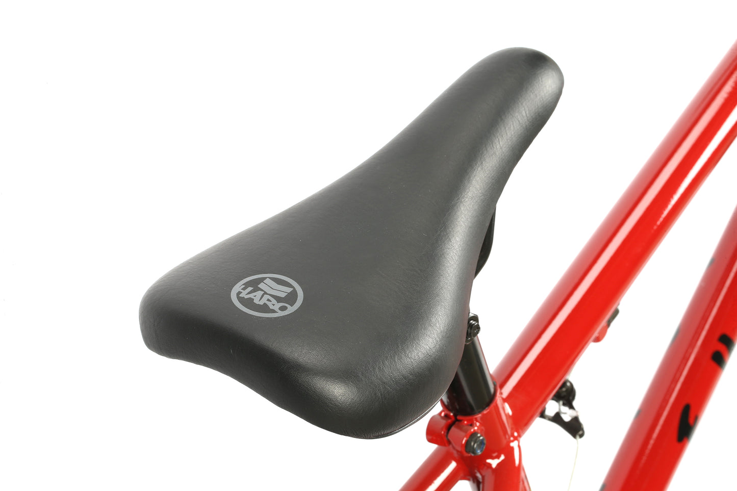 Close-up of a black HARO seat on a red Leucadia DLX BMX with chromoly cranks, seen from the rear-side angle.