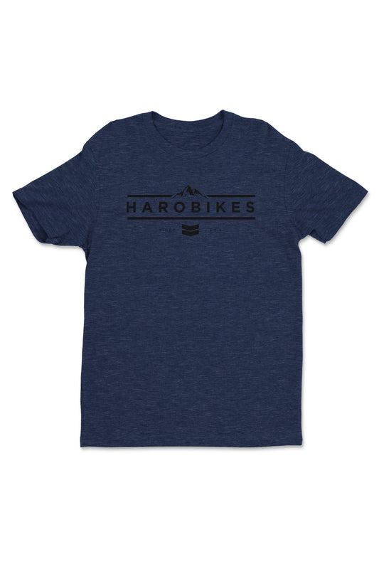The Haro MTB Rider Shirt by Haro Bikes is blue with HARO BIKES text, a mountain graphic above, and two curved lines below. It features a round neckline and has a casual design.