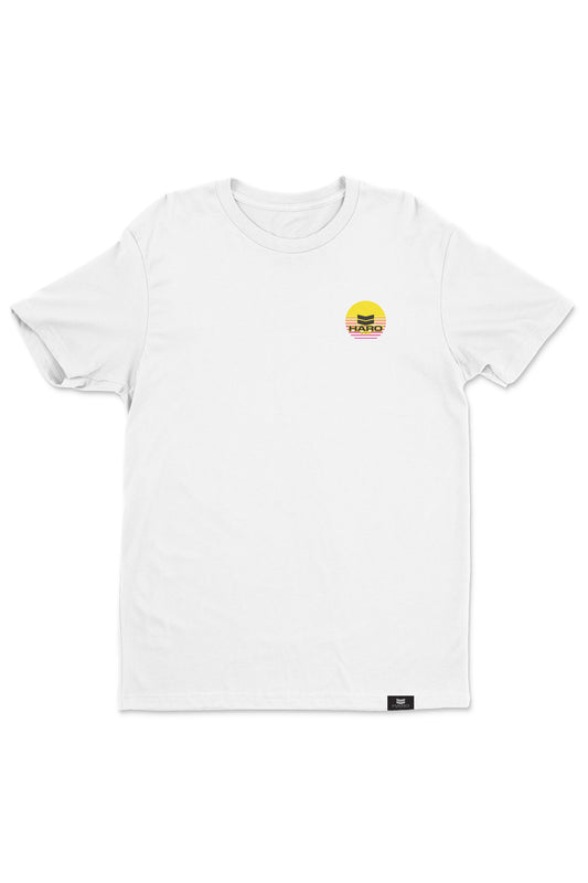 The Haro Sunset Shirt by Haro Bikes is a white T-shirt showcasing a small graphic of a yellow sunrise with a red rectangle on the upper left chest and features a small black label on the bottom hem.