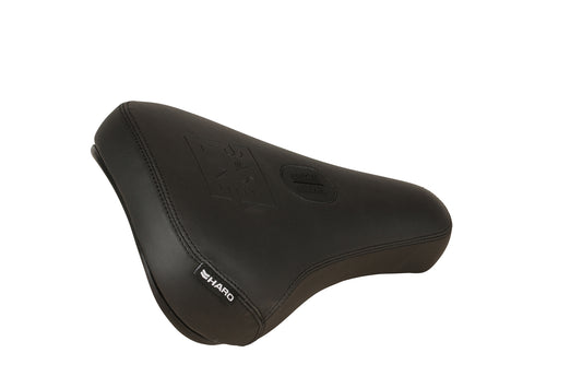 The Haro Bikes Baseline Pivotal Seat is a black bicycle seat made from PU leather, featuring visible stitching and a textured surface. Its sleek, contoured design ensures comfort and includes embossed logos like the Haro tag.