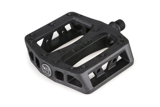 The Baseline Plastic Pedals by Haro Bikes feature a black nylon, textured surface with visible branding. They have a flat design with multiple openings for grip and include a robust chromoly spindle for secure attachment to the bike crank arm.