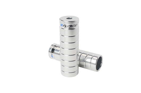 Two silver cylindrical Fusion Pegs from Haro Bikes, made of 7075 aluminum with engraved crisscross grooves. The top peg features FUZION and a small hole at one end, finished in shiny metallic.