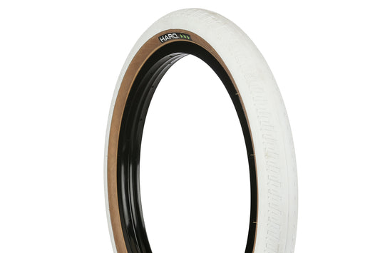 The HPF Tire by Haro Bikes features a white tread, brown sidewall, and black rim. Captured at an angle against a white background, it showcases the Haro logo on its side and is ideal for ramp or street riding.