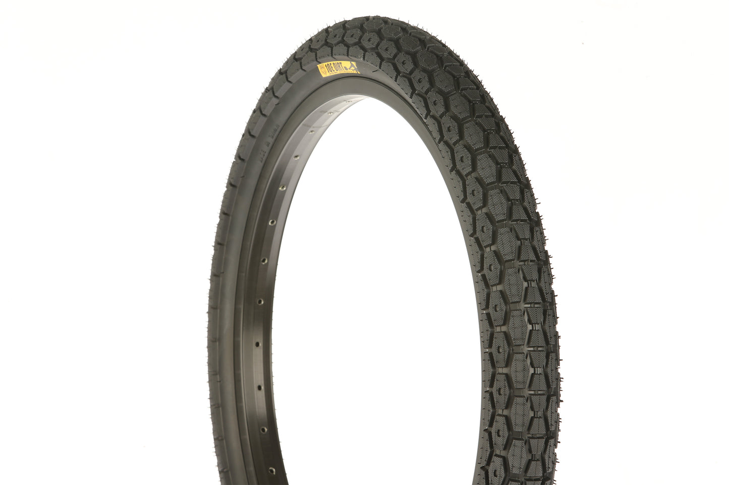 A close-up of a Joe Dirt Tire highlights its heavy tread design for durability. The tire, mainly black with a yellow label on the side, belongs to the Haro Bikes brand and is set against a plain white background.