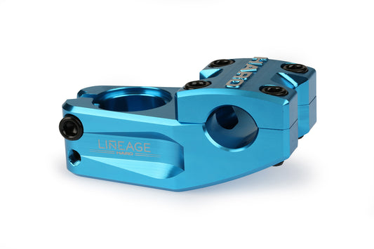 The Haro Bikes Lineage Top Load Stem is a sleek blue anodized bicycle accessory crafted from 6061 aluminum. Expertly CNC machined, it features the name Lineage engraved on the side and includes four visible bolts for secure attachment and easy adjustment.