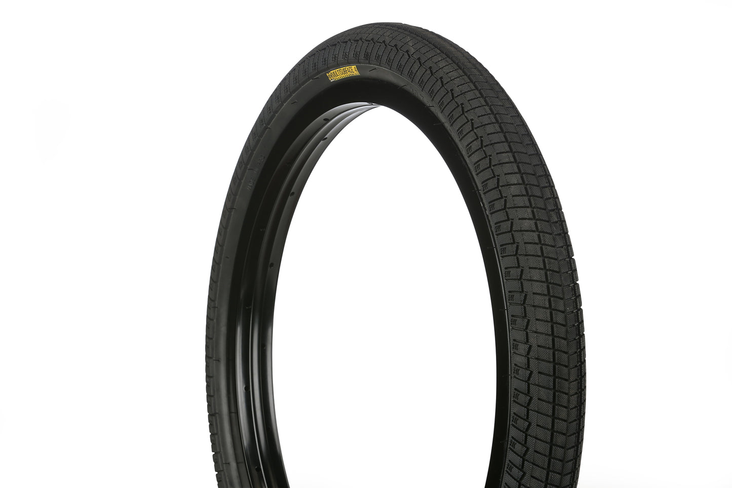 A close-up of the Haro Bikes MS-4 Tire, featuring its black, knurled wrap-around tread pattern, displayed against a white background. The tire stands upright, highlighting its circular shape and detailed sidewalls.
