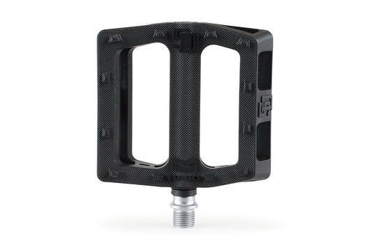 The SD Plastic Pedals by Haro Bikes are black, rectangular BMX pedals that feature polycarbonate bodies with two large openings. They have a textured grip surface and a durable chromoly spindle, designed for performance and style, shown vertically against a plain white background.