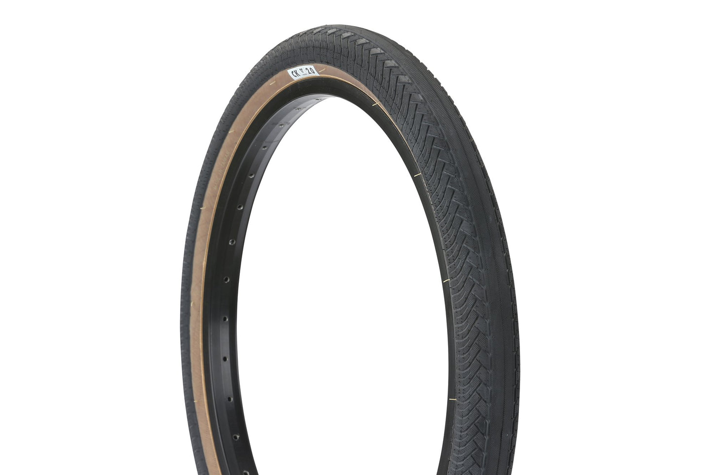 The Premium CK Tire, featuring a black zigzag tread and tan sidewall with micro knurled lugs, stands upright, showcasing its low-profile directional design and a rim with holes for spokes, set against a white background.