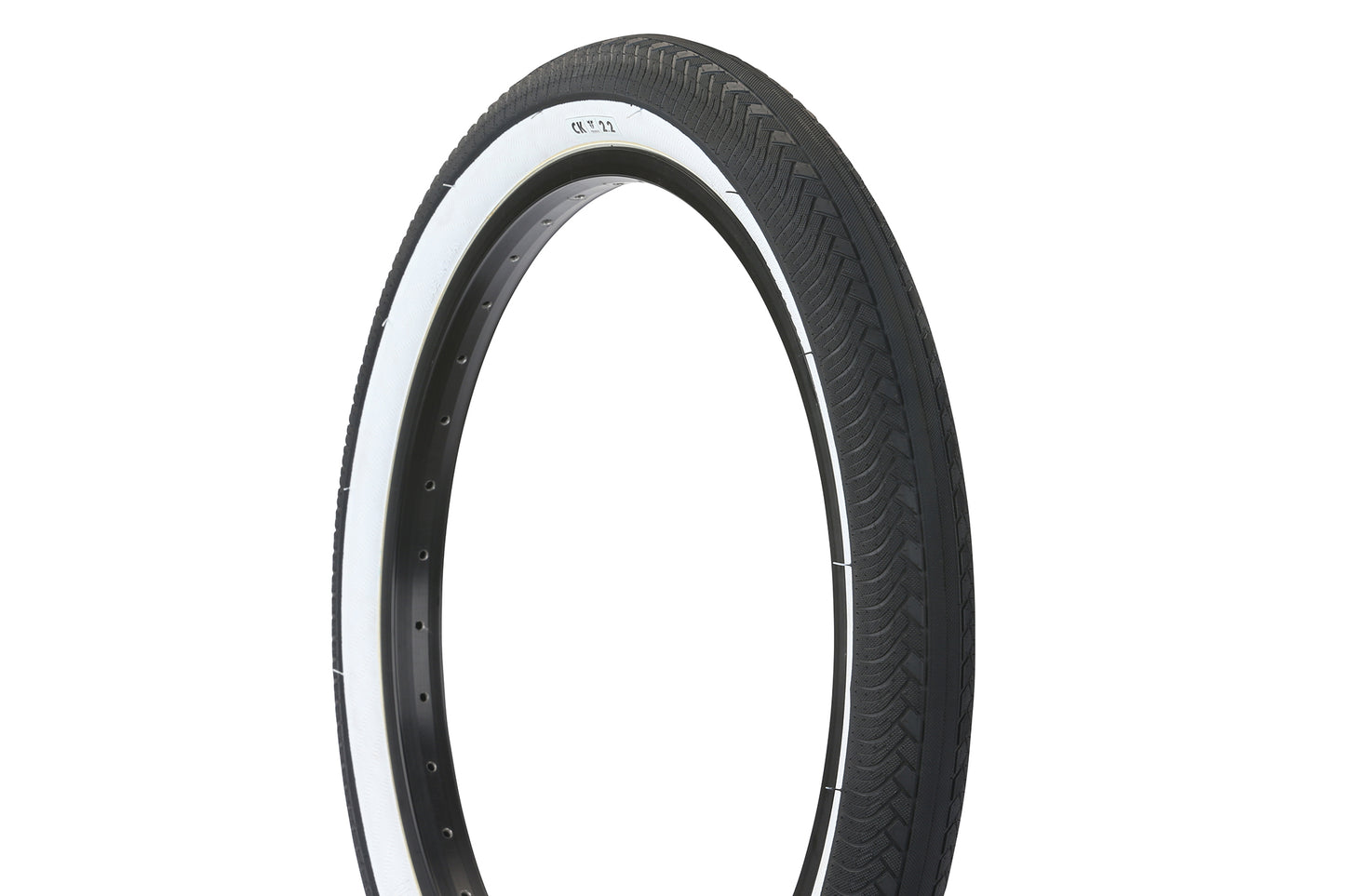 The Premium CK Tire features a white sidewall, black tread pattern, and micro knurled side lugs. Its thin profile and smooth centerline are showcased when the tire is upright, emphasizing its minimalistic design.