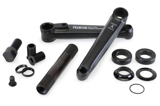 The Premium Trestle 24mm Cranks, made with durable chromoly, are displayed on a white background with black crank arms and components like screws, washers, and brackets. The arms have inscriptions and come with a lifetime warranty for peace of mind.
