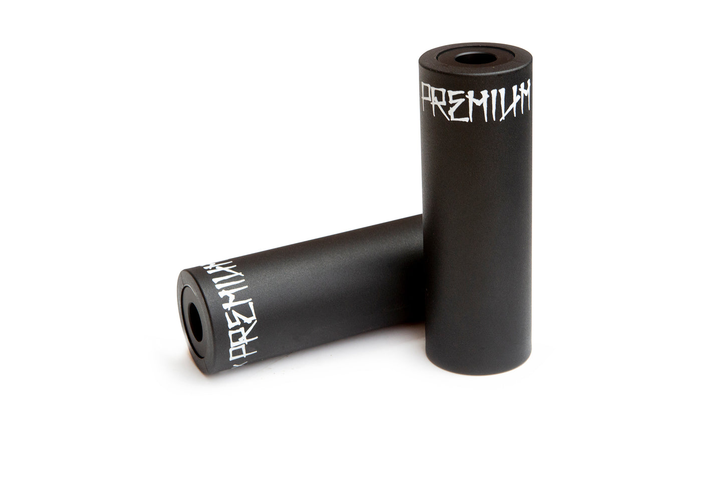 Two black Premium Plastic Pegs, featuring a lightweight aluminum core with PREMIUM in white, boast durable nylon sleeves. One peg stands upright on the white surface while the other lies diagonally behind it, highlighting their sleek, hollow-centered design.