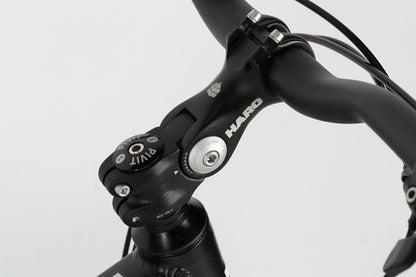 Close-up of the PD1 27.5 bicycles handlebar, focusing on the stem with Haro MTB branding. The image highlights the clean design and details, reminiscent of precise PD1 models, with cables contrasting against a plain white background.