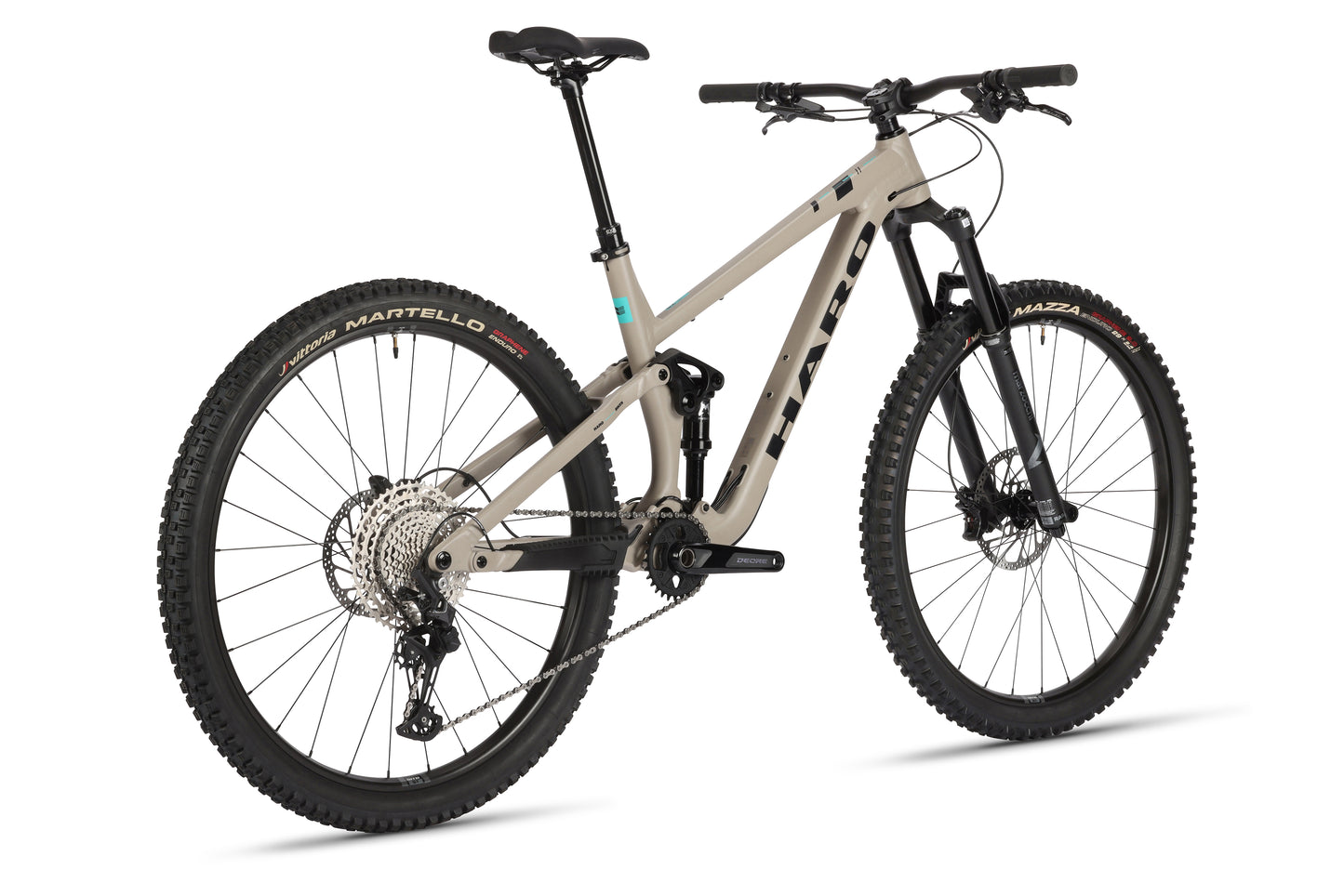 The Daley Alloy 2 by Haro MTB is a beige all-mountain 29er featuring a full-suspension aluminum frame, black handlebars, knobby tires, and prominent gears and disc brakes. The bike is angled slightly right against a white background.