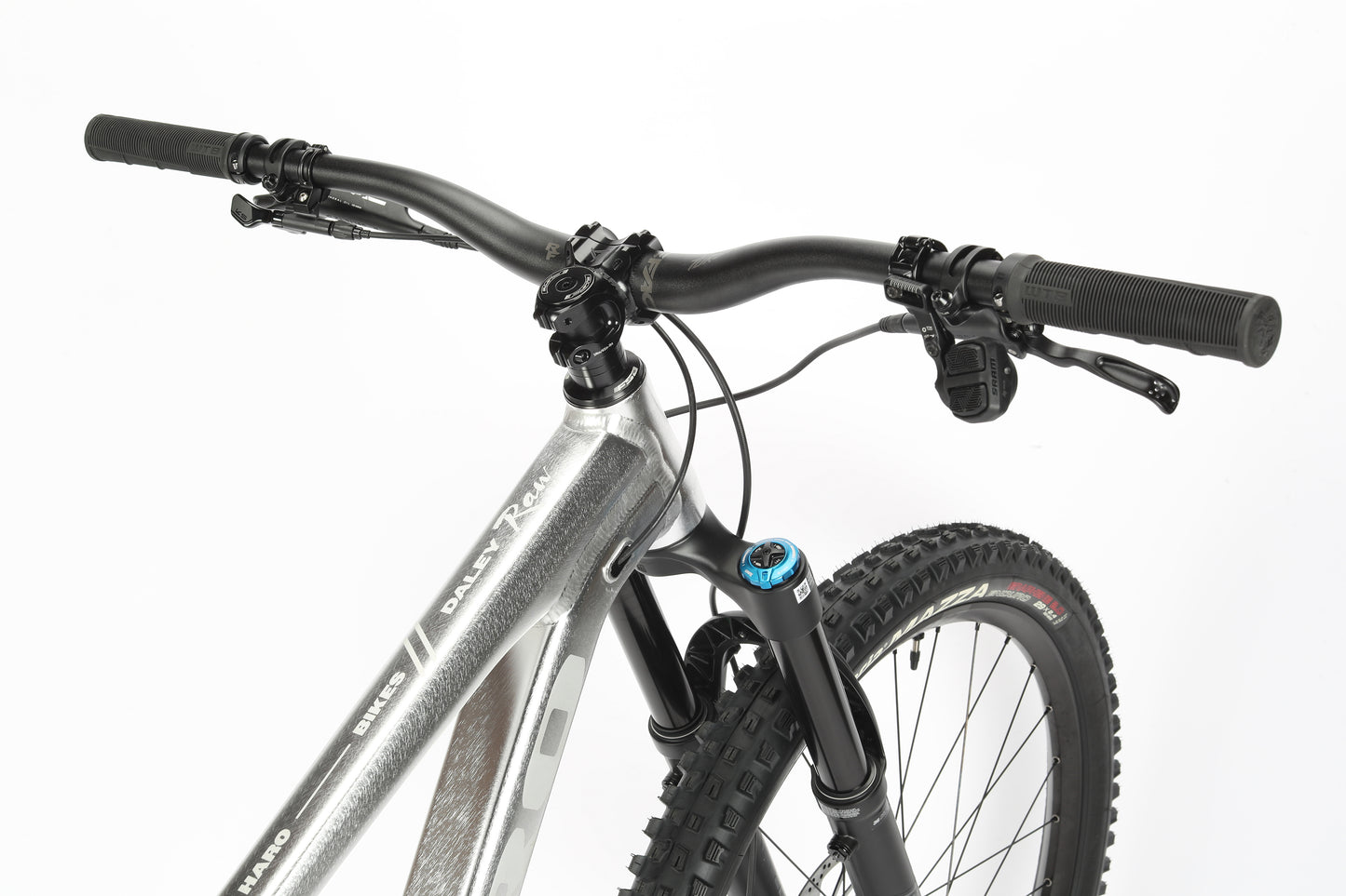 Close-up of a silver Haro MTB Daley Alloy LTD 1, highlighting the handlebars and front suspension fork. This limited edition bike features black grips, brake levers, and textured tires on a plain white background.