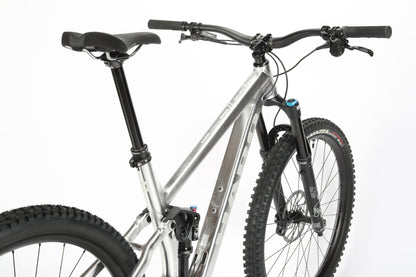 The Daley Alloy LTD 1 by Haro MTB is a sleek, limited edition mountain bike featuring a silver frame with black handlebars and thick black tires, designed for durability and perfect for off-road cycling enthusiasts.