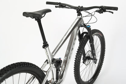 A sleek, silver Daley Alloy LTD 2 mountain bike from Haro MTB is pictured against a white background, showcasing thick knobby tires, a Fox front suspension fork, flat handlebars, a limited edition frame design, and a comfortable saddle.