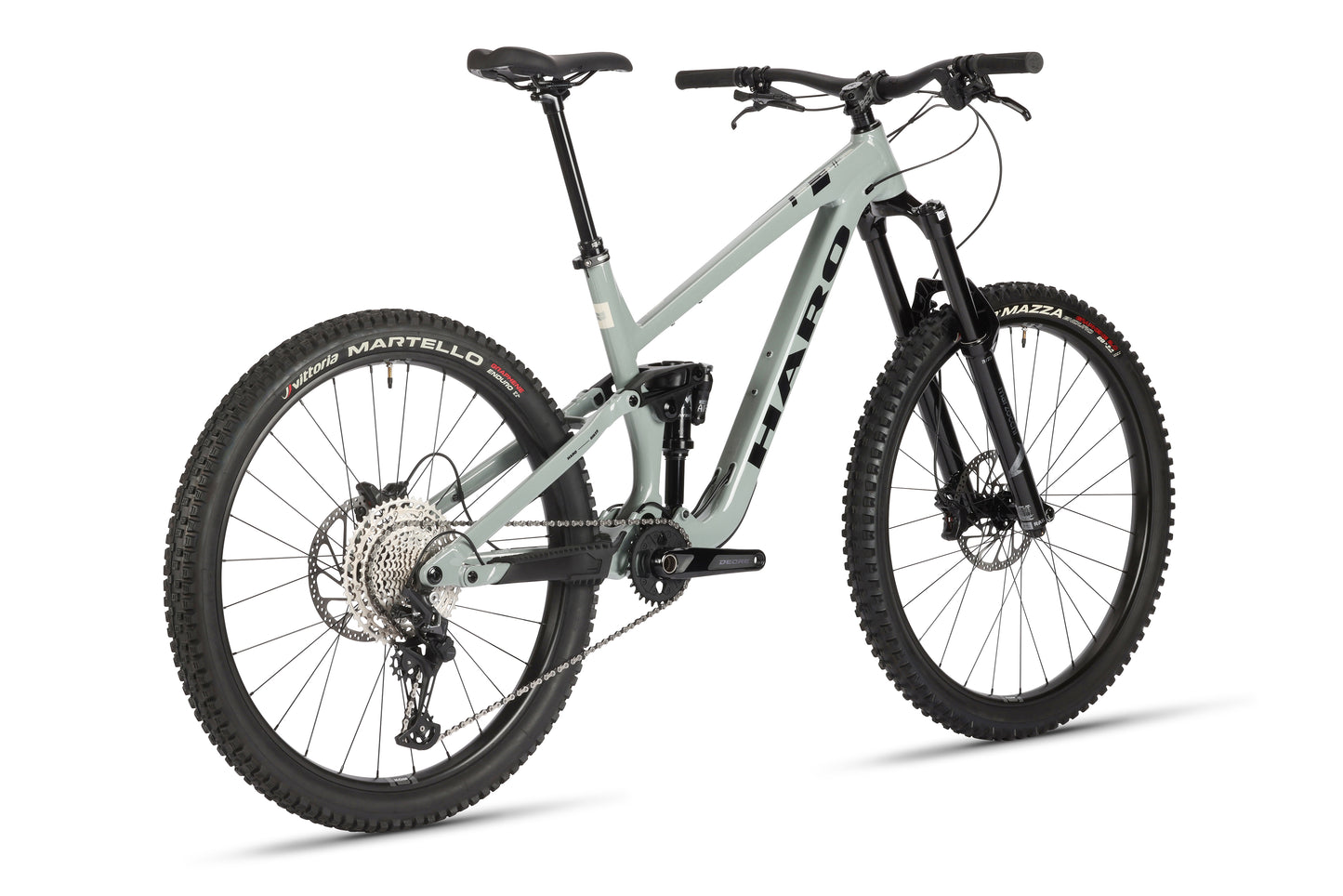 The Haro MTB Greer Alloy 2 mountain bike in gray features a performance alloy frame with knobby tires, dual suspension, large gear set, disc brakes, and mullet wheel configuration. Positioned to highlight its side and back, the brand name is visible on the frame.