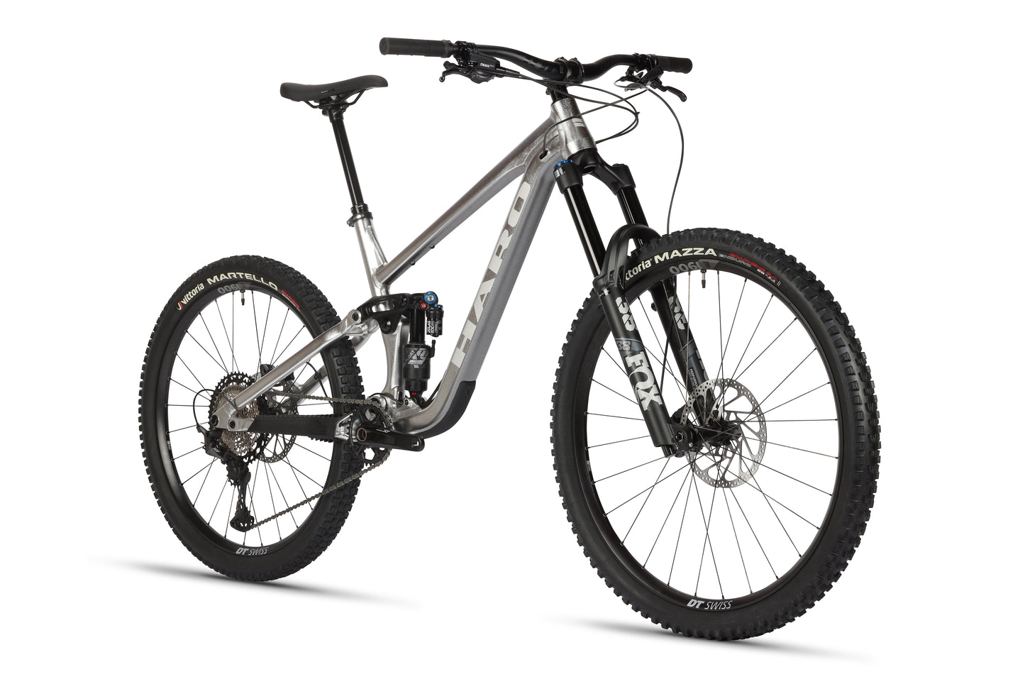 A silver mountain bike with large black tires, disc brakes, and a sturdy aluminum frame from Haro MTB. With Fox suspension for smooth rides, it boasts flat handlebars and a comfortable saddle. The product name Greer Alloy LTD 2 is prominently visible on the frame.