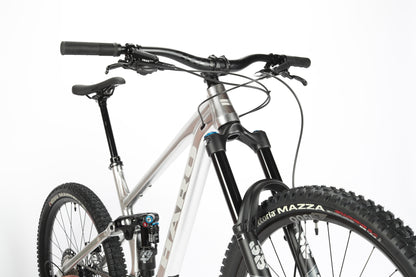 Close-up of a Haro MTB Greer Alloy LTD 2 showcasing the Fox suspension fork, handlebars, and aluminum frame. Features thick Vittoria Mazza tires and a modern design on a white background.