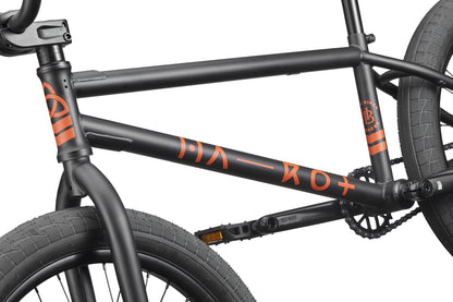 Close-up of the Burgess black BMX frame with orange graphics, designed for advanced riding and thick front and rear tires.