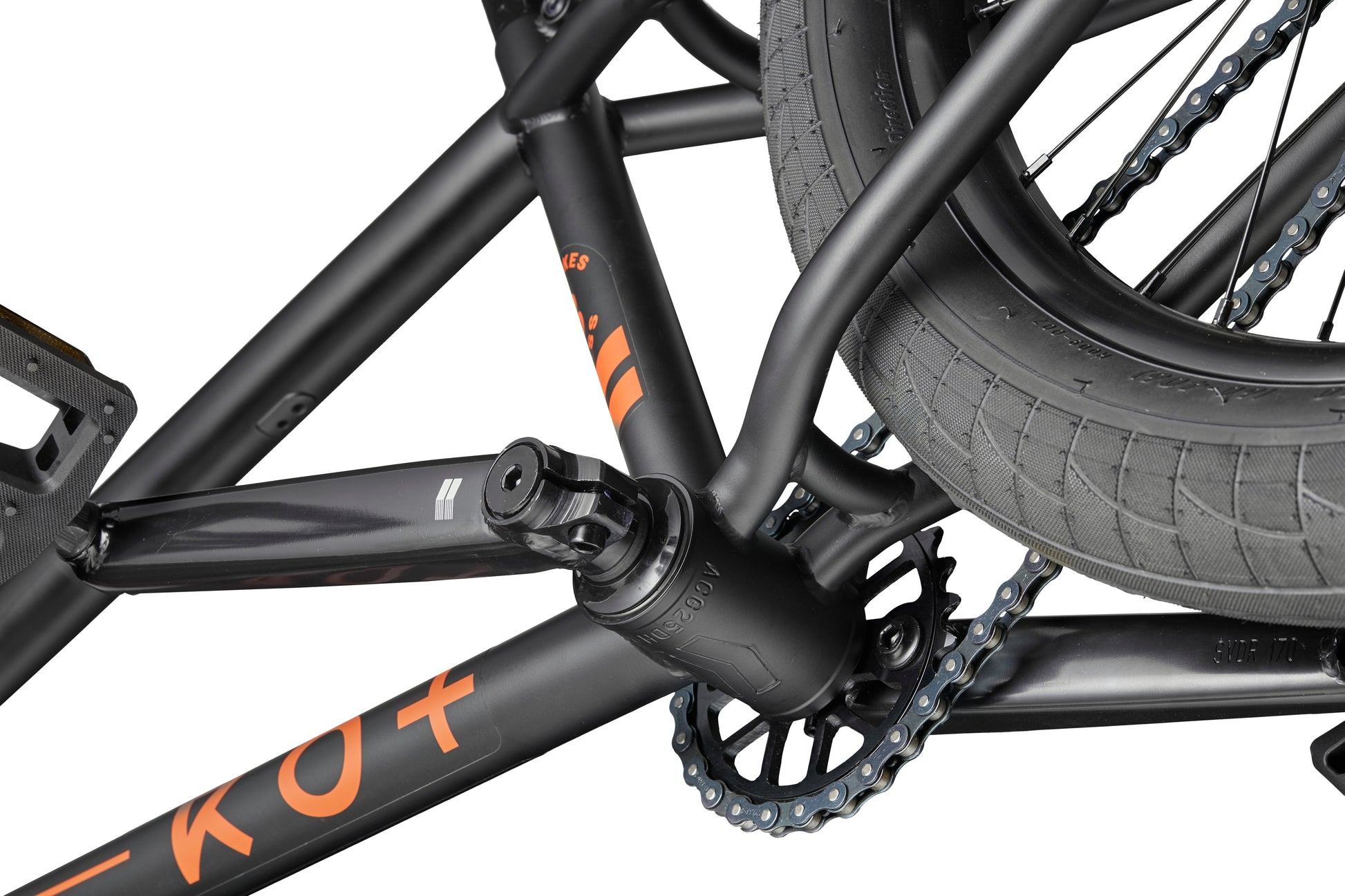 Close-up of a Burgess BMX bike crank, pedal, and chainring—made for versatile performance, featuring orange lettering on the frame.